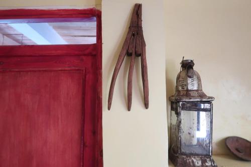 a red door with a lantern and utensils hanging on a wall at Gite Megdaz in Megdaz
