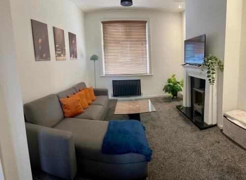 a living room with a couch and a fireplace at House In South Tyneside in Hebburn-on-Tyne