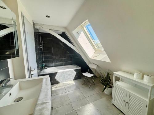 a bathroom with a sink and a bath tub at Le Douare, Proche centre-ville, Parking in Morestel
