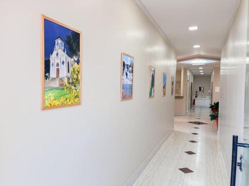 a hallway in a hospital with paintings on the walls at Palace Hotel in Cristalina