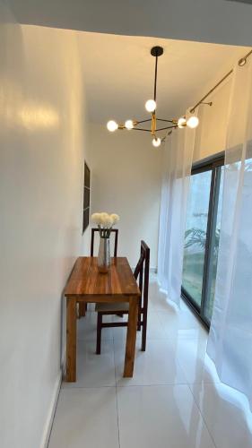 a dining room with a wooden table and a window at Appartement avec Piscine in Lomé
