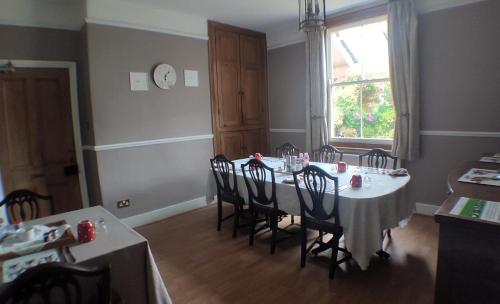 a dining room with a table with chairs and a window at Winton House in Stratford-upon-Avon