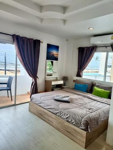 a bedroom with a large bed with purple curtains at Beach front B3 Marie Guest house in Jomtien Beach