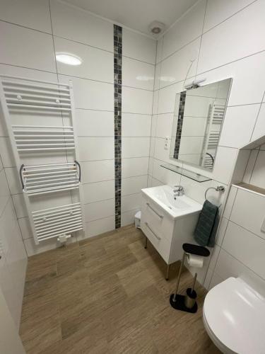 a white bathroom with a sink and a mirror at Dalyan-Home in Boppard