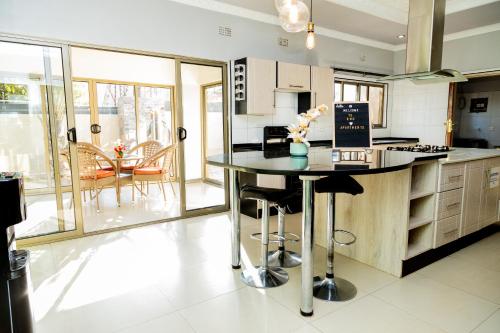 Una cocina con encimera y mesa con sillas. en EMC Luxury 4BR Villa ,Pool, Solar , Starlink Wifi, en Lusaka