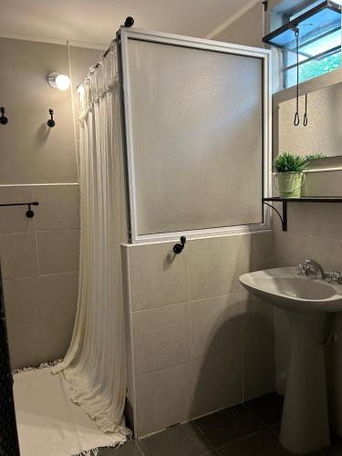 een badkamer met een douchegordijn en een wastafel bij Casita de Barrio in Lobos