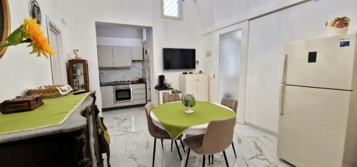 a kitchen with a green table and a white refrigerator at La Corte dei Sarti in Copertino