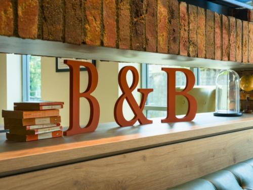 a large red sign on a shelf with books at B&B HOTEL Warrington in Warrington