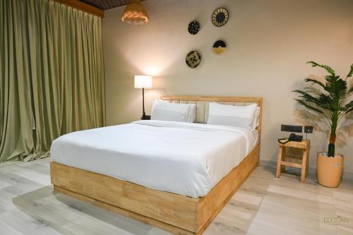 a bedroom with a large bed with white sheets at The Elysian Boutique Stays - Havelock in Havelock Island