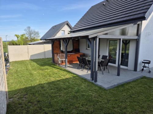 Un patio con una mesa y sillas en un patio. en Sosnowe Wzgórze - Wypoczynek w Zagórzu Śląskim 3, en Zagórze Śląskie