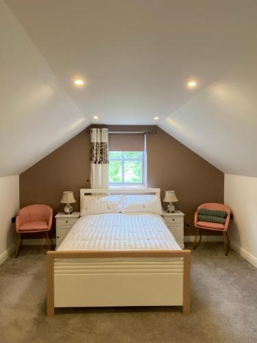 1 Schlafzimmer mit einem Bett mit 2 Stühlen und einem Fenster in der Unterkunft Riverside Cottage in Square