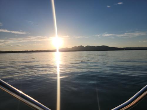 a boat on the water with the sun setting at Paradise home with king bed & room for the family in Lake Havasu City