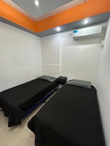 a room with two beds and a heater at Departamento Rojas 1 in San Fernando del Valle de Catamarca