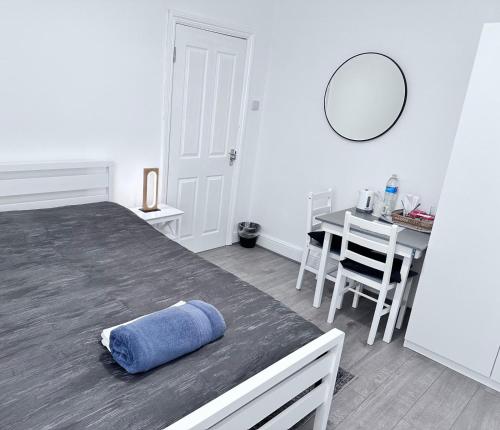 a bedroom with a bed and a table with a mirror at Watford Junction Stay in Watford