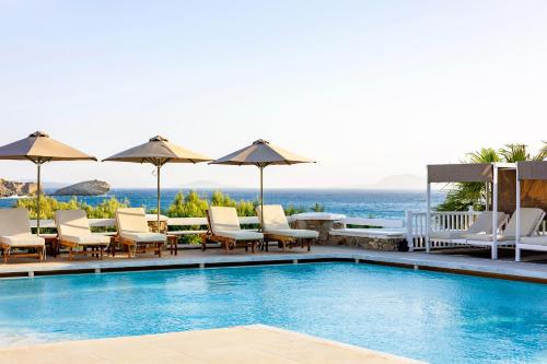 a pool at a resort with chairs and umbrellas at San Marco Hotel and Villas in Houlakia