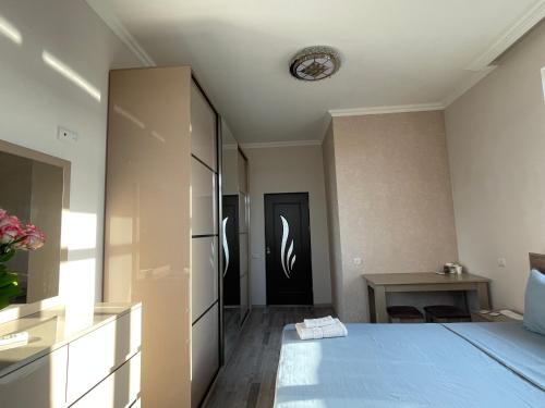 a bedroom with a blue bed and a table at Ruz & Arian Near Zvartnots Airport in Pʼarakʼar