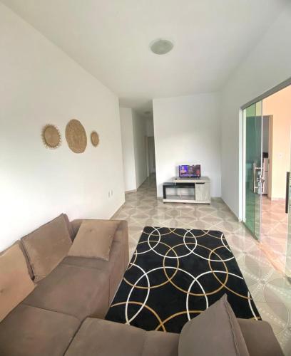 a living room with a couch and a rug at Cacao's Guaibim Residence in Valença