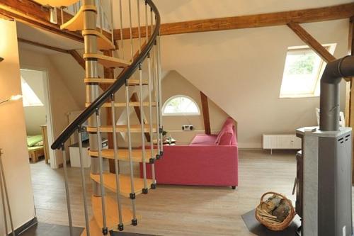 a spiral staircase in a living room with a red couch at Ferienwohnung Müller-Wulf in Schleswig