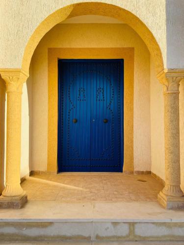 a blue door in the side of a building at Rayhana Guest House Midoun Djerba in Midoun