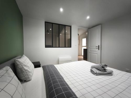 Un dormitorio con una cama y una ventana en la pared. en Bleu océan cosy avec accès autonome, en Villejuif