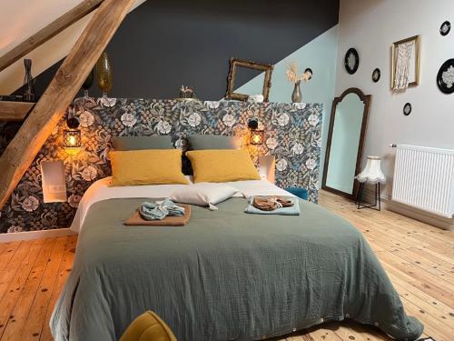 a bedroom with a large bed with two towels on it at Au Pressoir de Boisy in Pouilly-les-Nonains