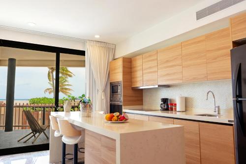 a kitchen with a counter with a bowl of fruit on it at It Beach Condo in Playa del Carmen