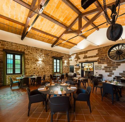 a restaurant with tables and chairs and a brick wall at Airport sicily home palermo in Carini
