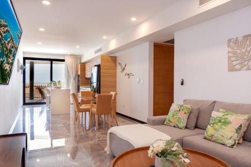a living room with a couch and a table at It Beach Condo in Playa del Carmen