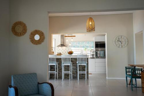 a living room with a kitchen with a bar and chairs at Villa Pwani in Baie du Tombeau
