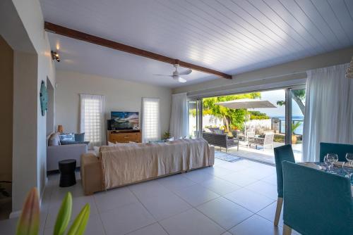 a living room with a bed and a sliding glass door at Villa Pwani in Baie du Tombeau