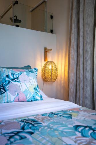 a bedroom with a bed with a pillow and a lamp at Villa Pwani in Baie du Tombeau
