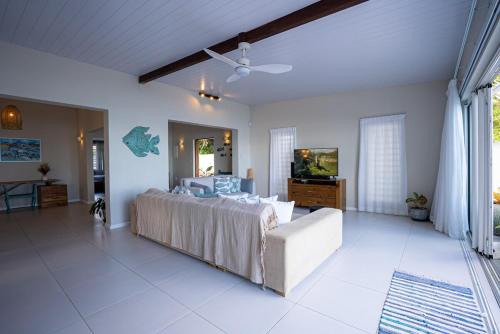 a large bedroom with a large bed and a couch at Villa Pwani in Baie du Tombeau