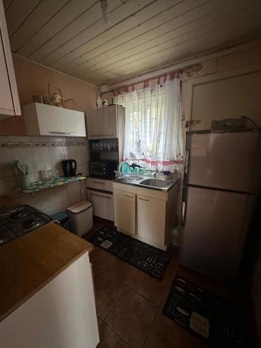 a small kitchen with a refrigerator and a sink at Casa en el Tabo 3 dormitorios 1 baño, Villa Cerrada, a 2 cuadras de la Playa Chepica in El Tabo