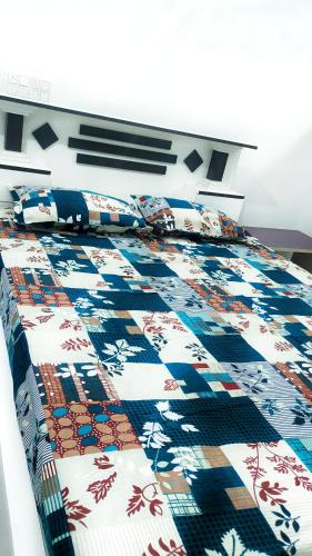 una cama con una colcha de colores encima en Jagadeeshwara comforts kalasa, en Kalasa