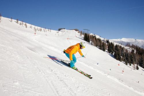 a person is skiing down a snow covered slope at Haus Bergland in Bad Kleinkirchheim