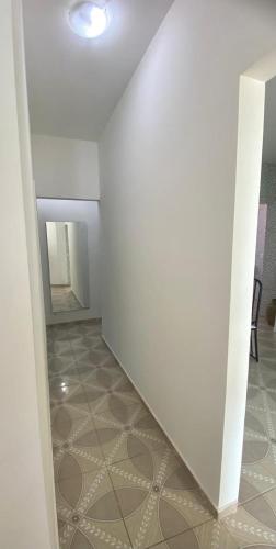a hallway with a white wall and a mirror at Cacao's Guaibim Residence in Valença
