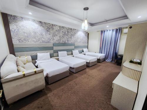 a waiting room with white couches and a painting at شقق العصر الماسي للشقق المفروشة - Al Asr almasi Suite Apartments in Al Madinah