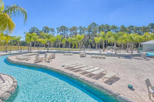 a resort with a pool and lounge chairs and palm trees at The Wharf 912 in Orange Beach