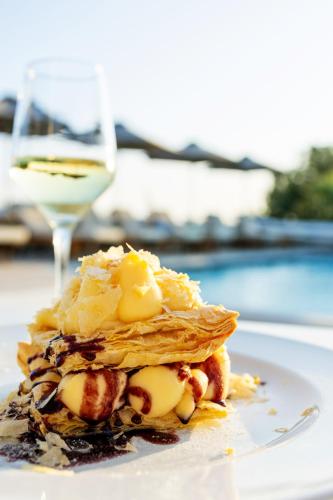 a dessert on a white plate with a drink at San Marco Hotel and Villas in Houlakia