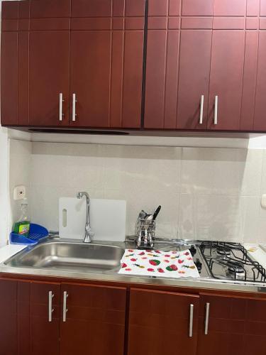 a kitchen counter with a sink and a stove at Tayra Living Suites in Mocoa