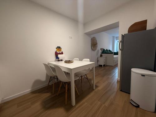 a kitchen with a white table and chairs in a room at Habita Estremoz in Estremoz
