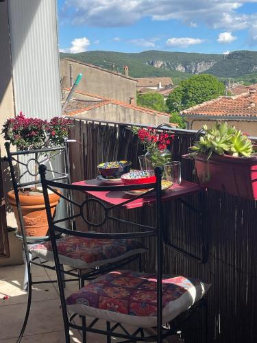 a table and chairs on a balcony with flowers at La Belle Vue in Ganges
