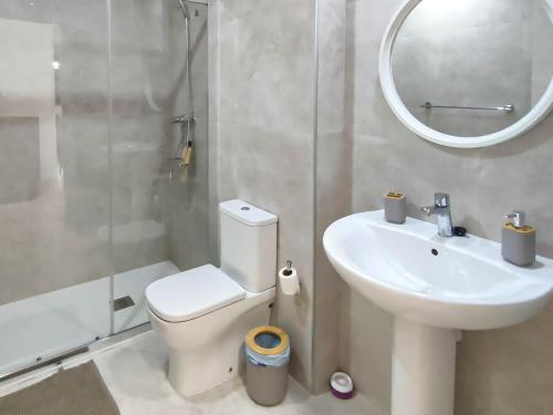 ein Badezimmer mit Toilette, Waschbecken und Spiegel in der Unterkunft Casa Rural Paseo de cuento in Villarquemado