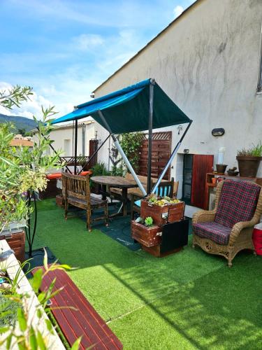 a patio with a table and chairs and a tent at La Belle Vue in Ganges