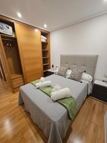 a bedroom with a large bed with towels on it at Natalia in Allariz