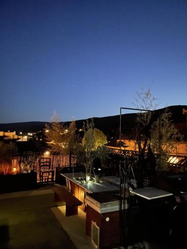 a patio with a table and benches at night at La Belle Vue in Ganges