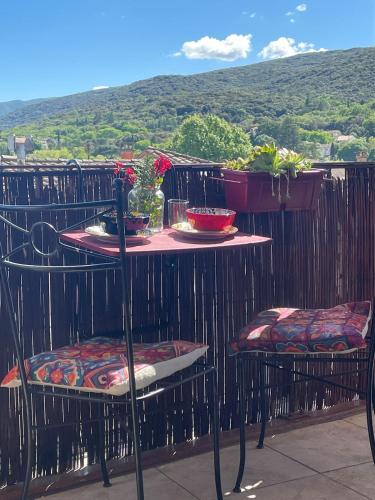 a table and two chairs with flowers on a balcony at La Belle Vue in Ganges