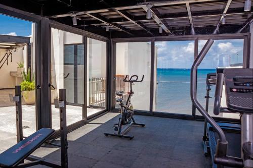 a gym with a view of the ocean at It Beach Condo in Playa del Carmen