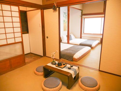 a bedroom with a bed and a mirror and a table at 9Stay西浅草 in Tokyo