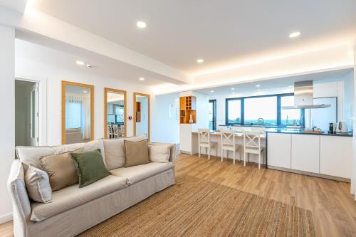 a living room with a couch and a kitchen at Ápice - by Azores Green Villas in São Vicente Ferreira